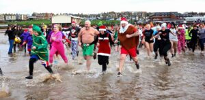 Group running into sea - Christmas Day swim