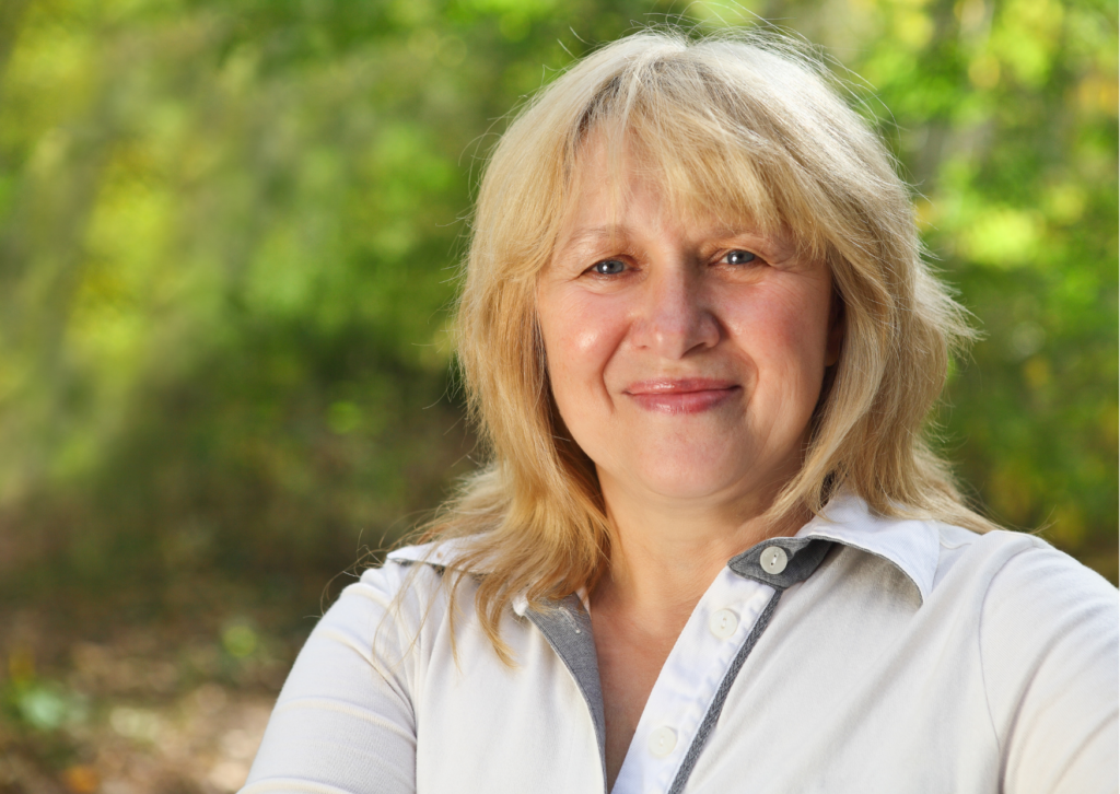 Woman smiling with trees in background