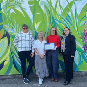 The Cambridgeshire and Peterborough NHS Foundation Trust Dementia Carers Support Service team with a certificate of the Caring Together Charity Carer Friendly Tick Award