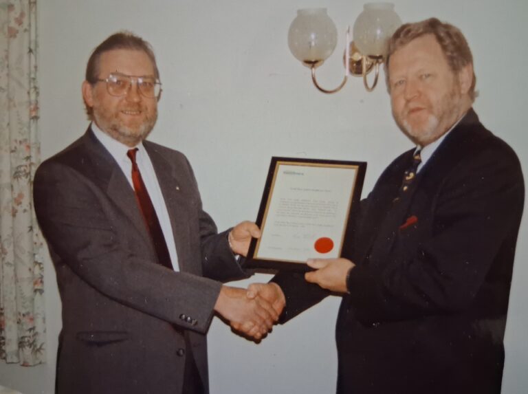 Derek Bond (left) being awarded a certificate.