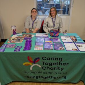 Caring Together Charity staff Claire Rogers (left) and Laura Price sat behind a stall covered in leaflets