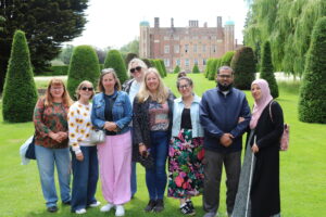 A group of parent carers stood in front of a large country house.