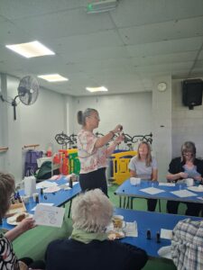 Woman doing a demonstration on aromatherapy oils to a group 