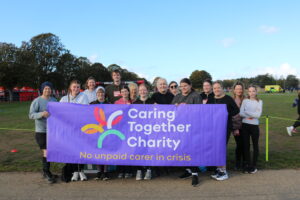 The Caring Together Charity team of runners stood behind a Caring Together Charity banner.