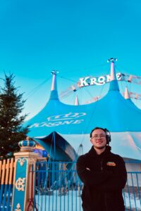 Former young carer James standing in front of a circus tent