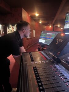 Former young carer James standing at a sound desk