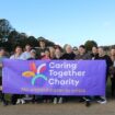 The Caring Together Charity team behind a Caring Together Charity banner.